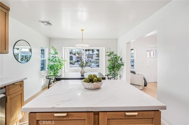 kitchen featuring visible vents, plenty of natural light, and a kitchen island