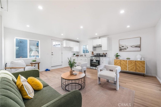 living room featuring recessed lighting, light wood-style floors, and baseboards