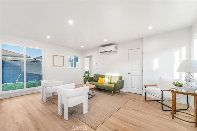 living area featuring a wall mounted AC, light wood-type flooring, and recessed lighting