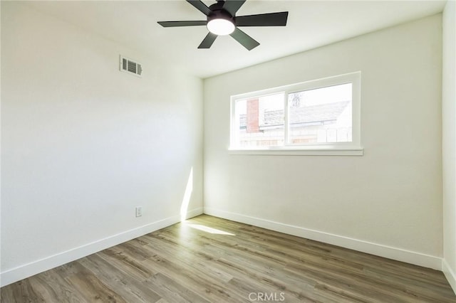 unfurnished room featuring visible vents, ceiling fan, baseboards, and wood finished floors