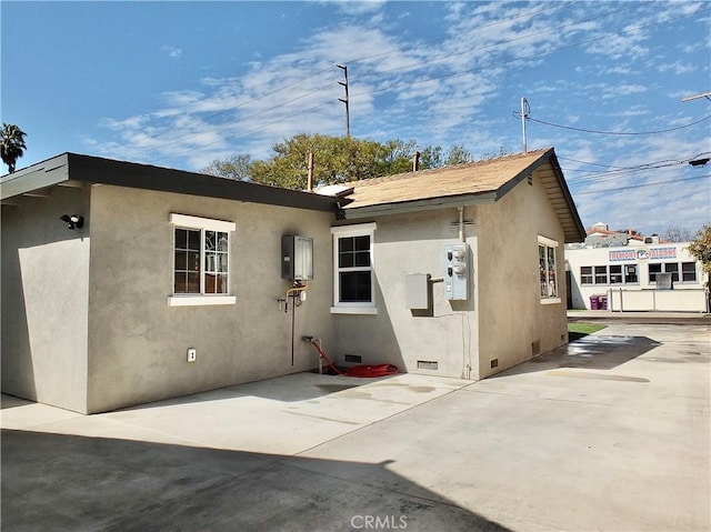 exterior space with crawl space, a patio area, and stucco siding