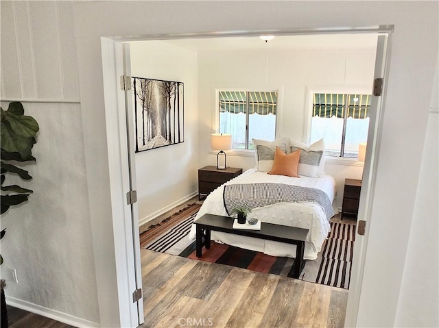 bedroom featuring baseboards and wood finished floors