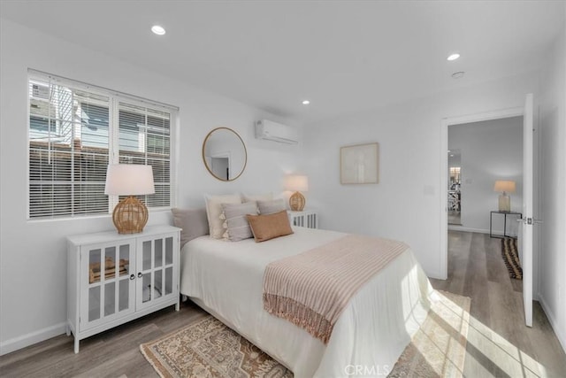 bedroom with recessed lighting, a wall mounted air conditioner, and wood finished floors