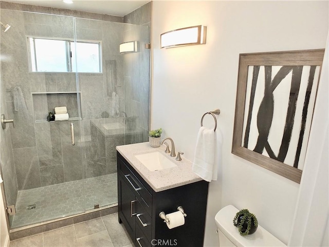 full bath with a stall shower, tile patterned flooring, vanity, and toilet