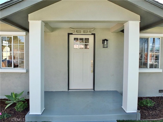 doorway to property featuring stucco siding