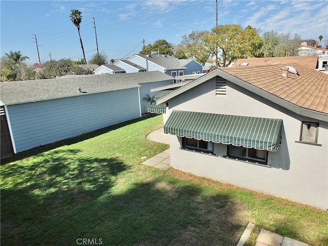 rear view of property with a lawn and stucco siding