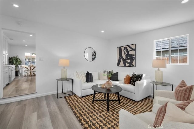 living room with baseboards, light wood-style flooring, and recessed lighting