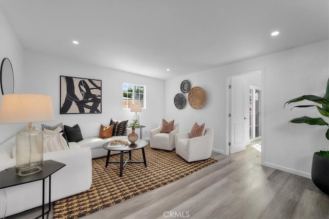 living area with recessed lighting, baseboards, and wood finished floors