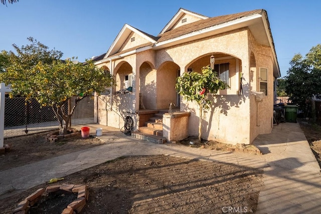 view of front of house with fence and stucco siding