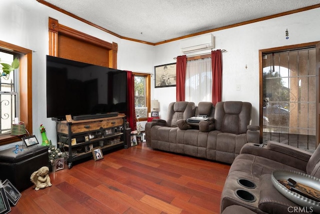 living room with a wall unit AC, crown molding, a textured ceiling, and wood finished floors