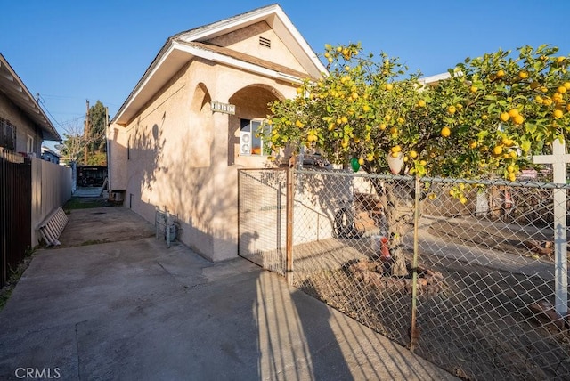 view of home's exterior with fence and stucco siding