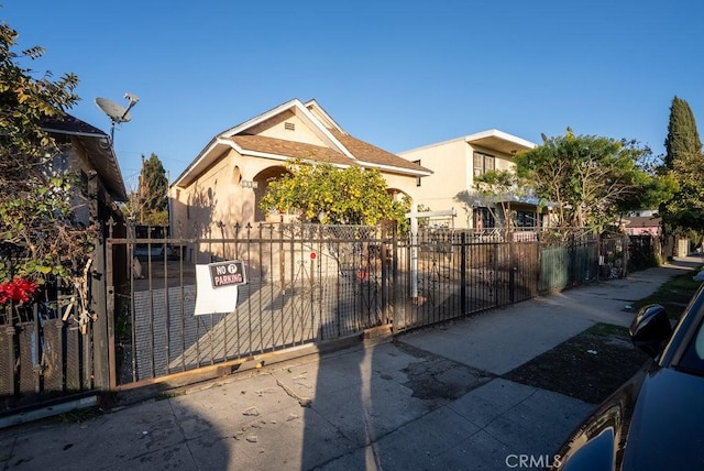 view of front of property featuring a fenced front yard, a gate, and stucco siding