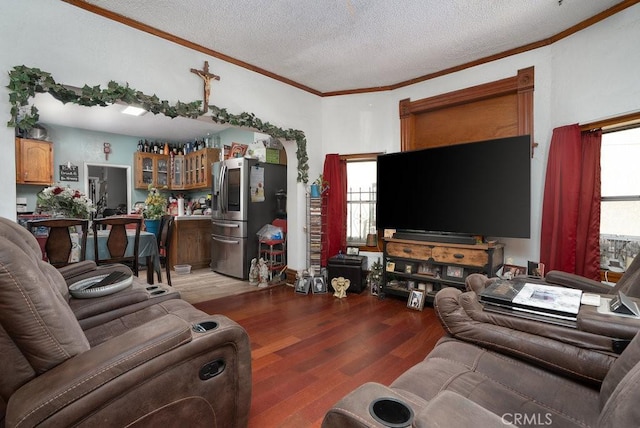 living area featuring a healthy amount of sunlight, crown molding, a textured ceiling, and wood finished floors