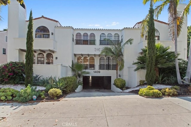 1409 Havenhurst Dr Unit 3, West Hollywood, CA 90046 - view of front of home with stucco siding, driveway, and a garage