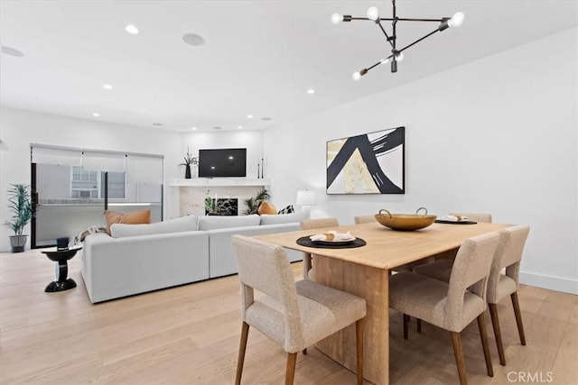 1409 Havenhurst Dr Unit 3, West Hollywood, CA 90046 - dining space featuring recessed lighting, a notable chandelier, light wood-style flooring, and a fireplace
