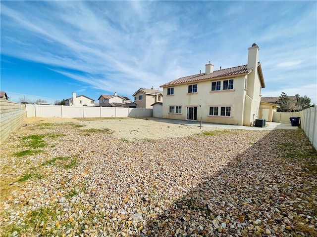 rear view of property with a chimney, a patio area, a fenced backyard, and stucco siding