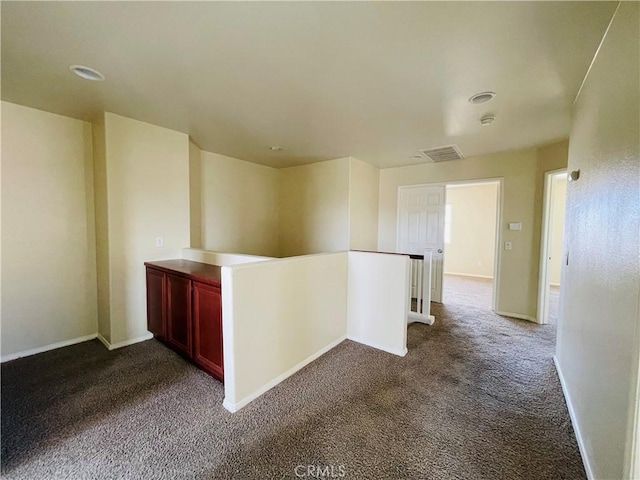 interior space featuring carpet floors, baseboards, and visible vents