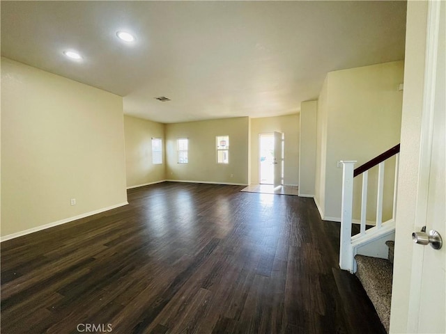 interior space with stairs, baseboards, and dark wood-type flooring