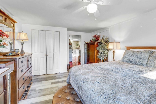 bedroom with light wood finished floors, ceiling fan, and a closet