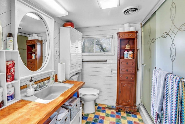 full bathroom featuring visible vents, toilet, tile patterned floors, a shower stall, and a sink