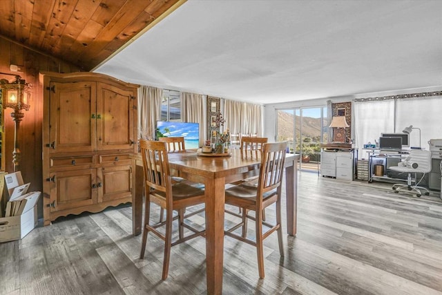 dining space featuring light wood-type flooring, wood ceiling, and vaulted ceiling