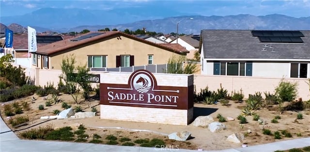 community sign with a mountain view and fence