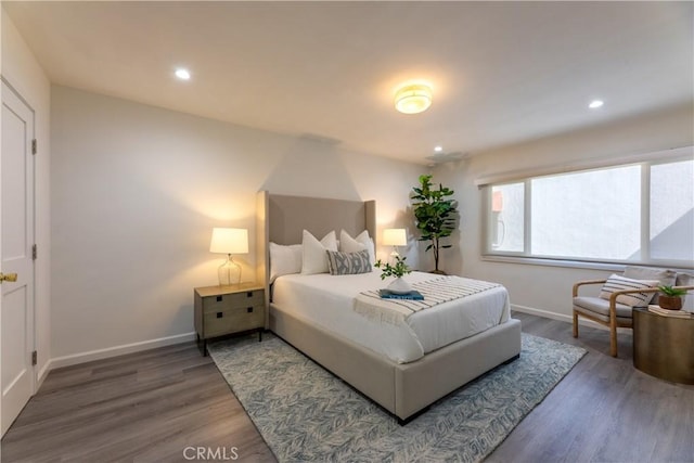 bedroom with recessed lighting, wood finished floors, and baseboards