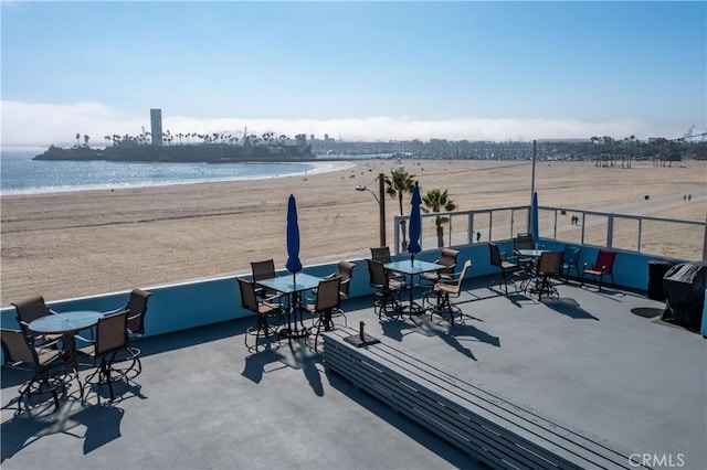 view of patio / terrace with a beach view and a water view