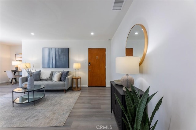 living area featuring baseboards, wood finished floors, and recessed lighting