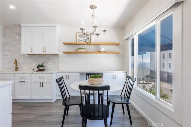 dining room with light wood-style floors, recessed lighting, a chandelier, and baseboards