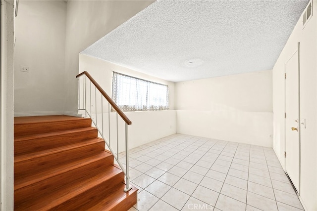 11331 Elliott Ave Unit 21, El Monte, CA 91732 - basement featuring stairs, a textured ceiling, and light tile patterned floors