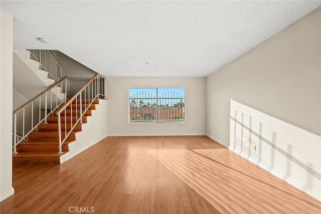 11331 Elliott Ave Unit 21, El Monte, CA 91732 - unfurnished living room with wood finished floors, stairs, a textured ceiling, and baseboards