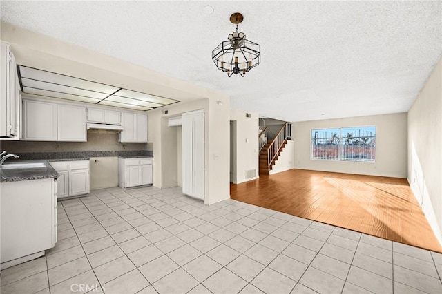 11331 Elliott Ave Unit 21, El Monte, CA 91732 - kitchen featuring light tile patterned floors, a sink, under cabinet range hood, open floor plan, and hanging light fixtures