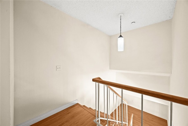 11331 Elliott Ave Unit 21, El Monte, CA 91732 - corridor featuring wood finished floors, baseboards, an upstairs landing, and a textured ceiling