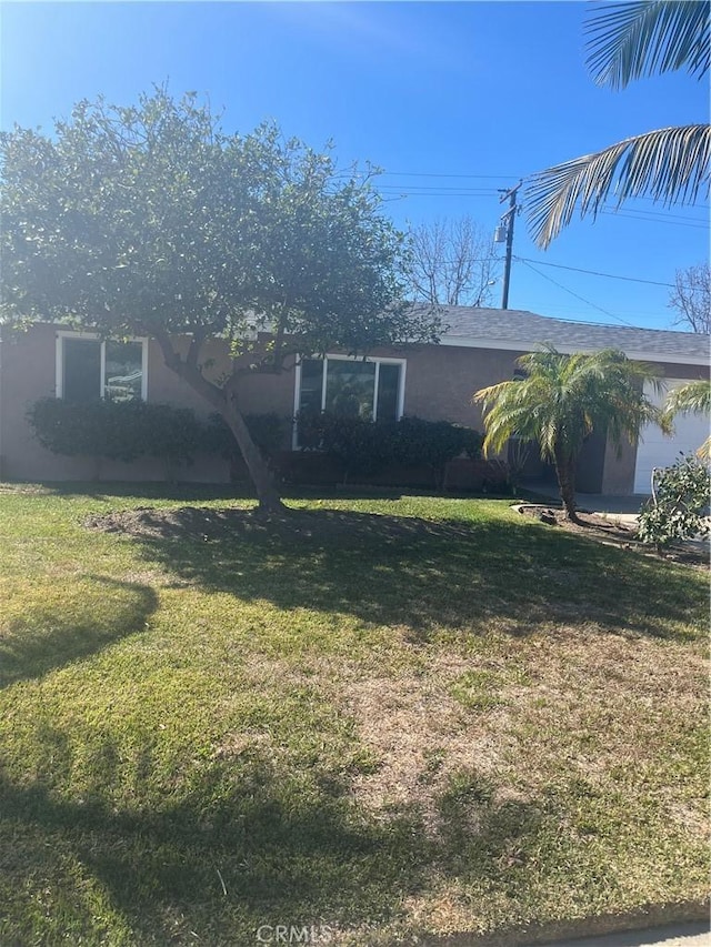 view of front of home with an attached garage and a front lawn