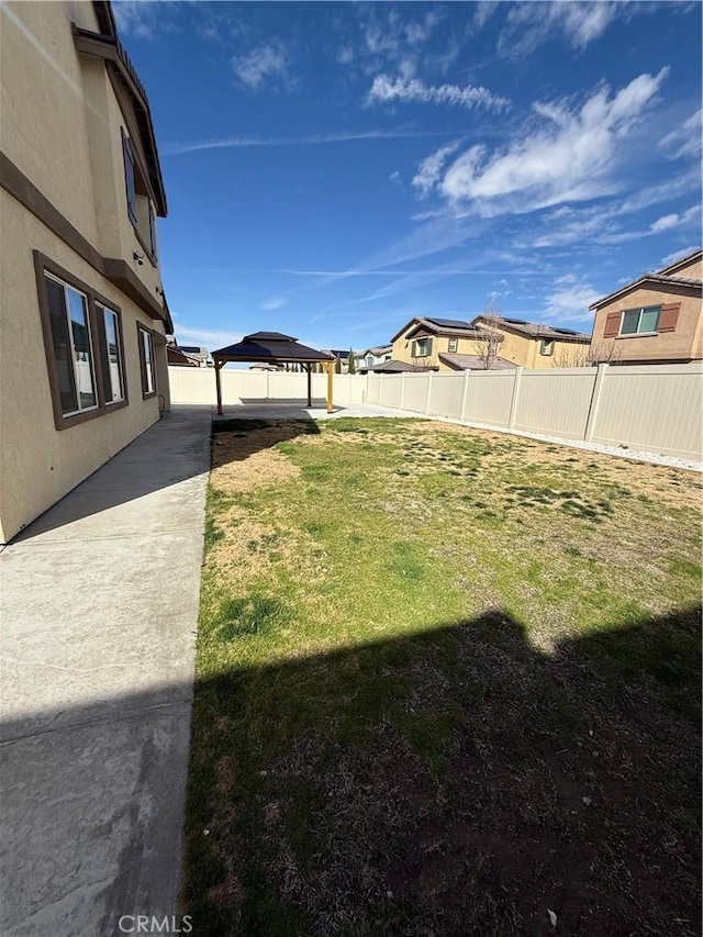 view of yard featuring a patio area, a fenced backyard, and a gazebo