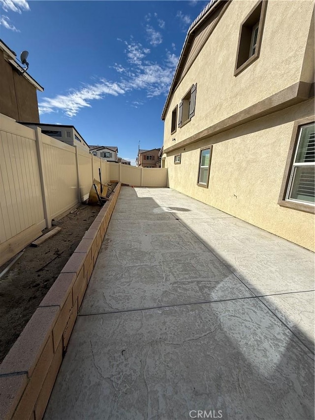 exterior space featuring stucco siding, a fenced backyard, and a patio