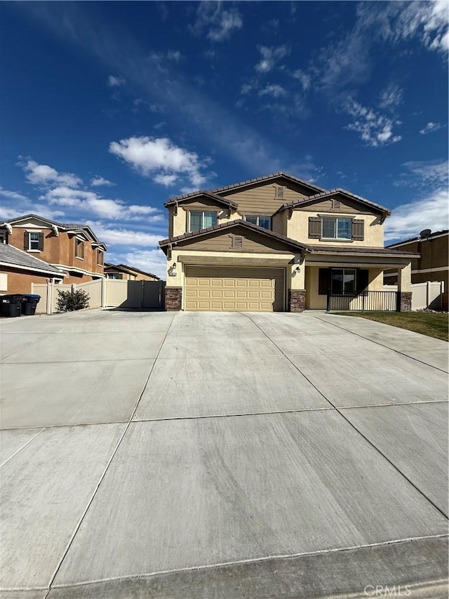 view of front of home featuring an attached garage, fence, concrete driveway, and stucco siding