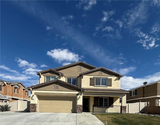 view of front of home featuring covered porch, fence, driveway, a tiled roof, and stucco siding