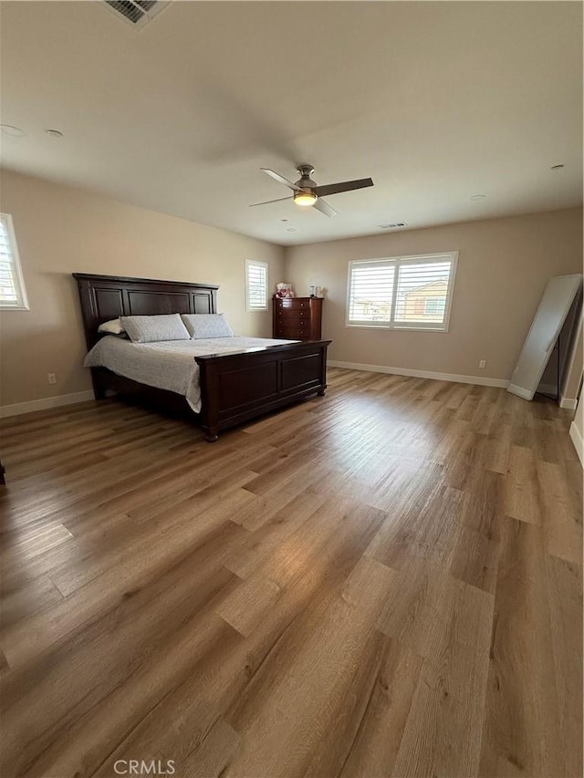 unfurnished bedroom with a ceiling fan, baseboards, visible vents, and light wood finished floors