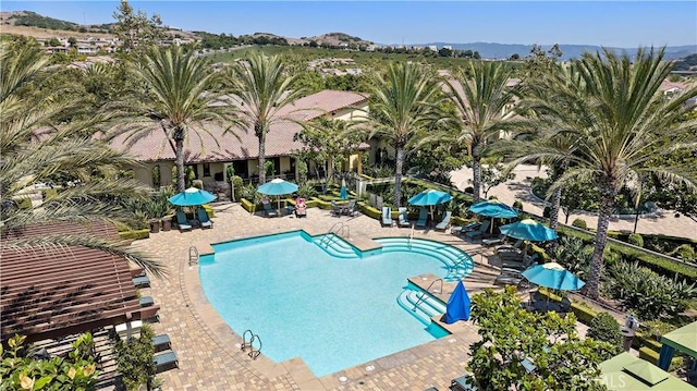 pool with a patio area and a mountain view