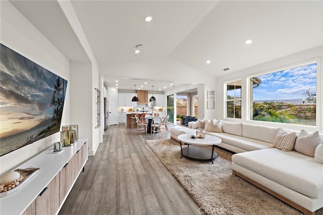 living room featuring recessed lighting, visible vents, vaulted ceiling, and wood finished floors