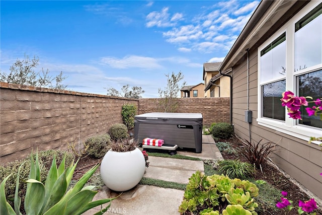 exterior space with a fenced backyard and a hot tub