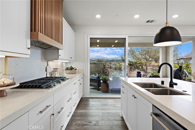 kitchen with visible vents, appliances with stainless steel finishes, wood finished floors, light countertops, and a sink