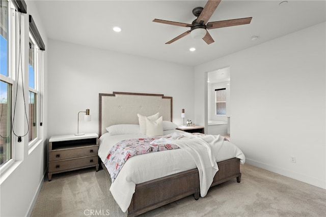 bedroom featuring light carpet, baseboards, a ceiling fan, ensuite bathroom, and recessed lighting