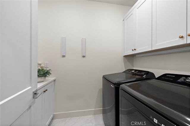 clothes washing area with washer and dryer, marble finish floor, cabinet space, and baseboards