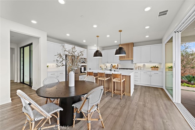 dining room featuring light wood-type flooring, visible vents, and recessed lighting