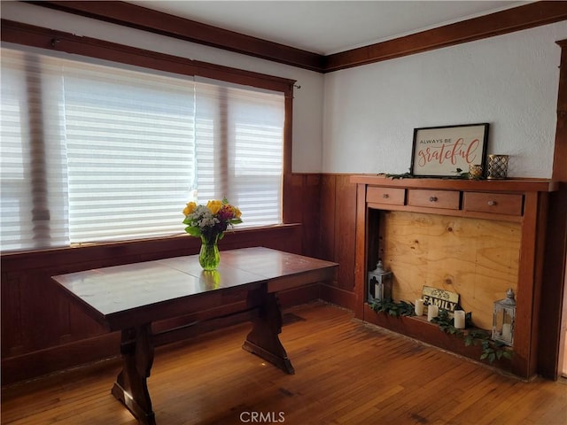 dining space featuring ornamental molding, breakfast area, and wood finished floors