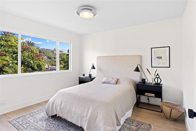 bedroom featuring baseboards and light wood finished floors