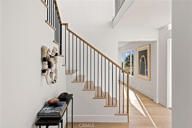 foyer with light wood-style floors, stairway, and baseboards